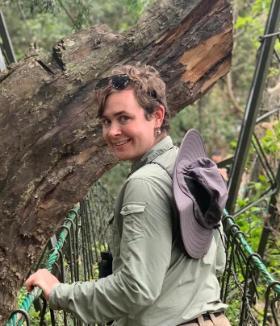 Image of Avery holmes looking over his shoulder in a forest