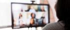 Woman in team meet via video conference looking at screen