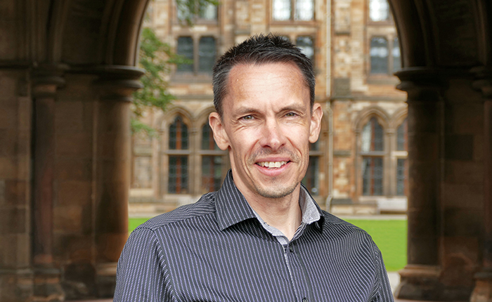 Domhnall Rintoul profile photo, standing in the cloisters at the University of Glasgow 