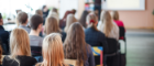 Pupils sit facing the teacher in a classroom.