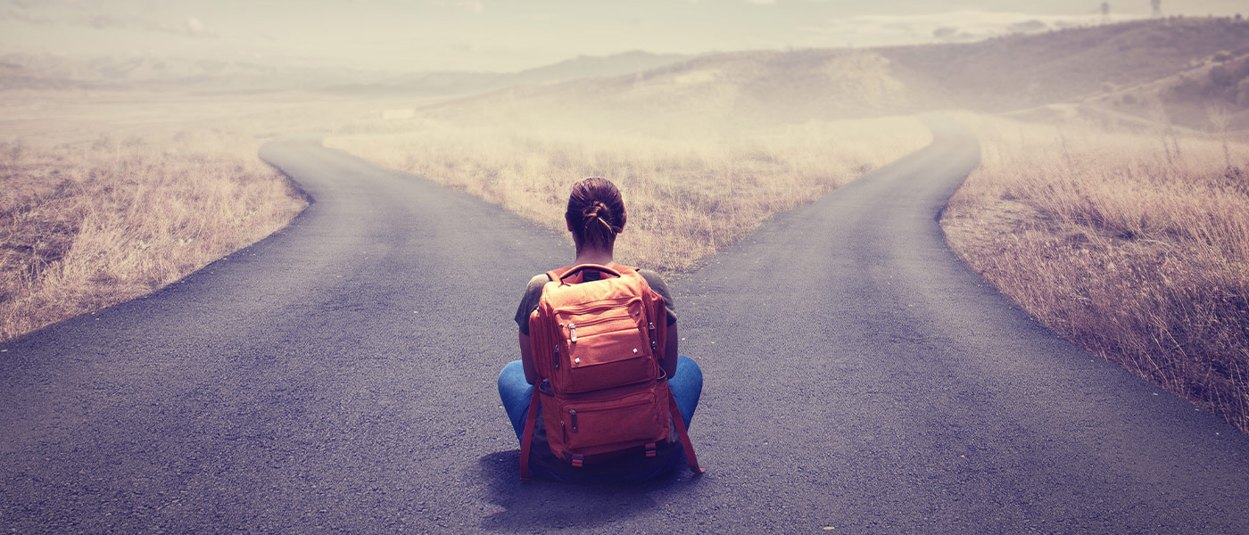 Student sitting at a crossroad