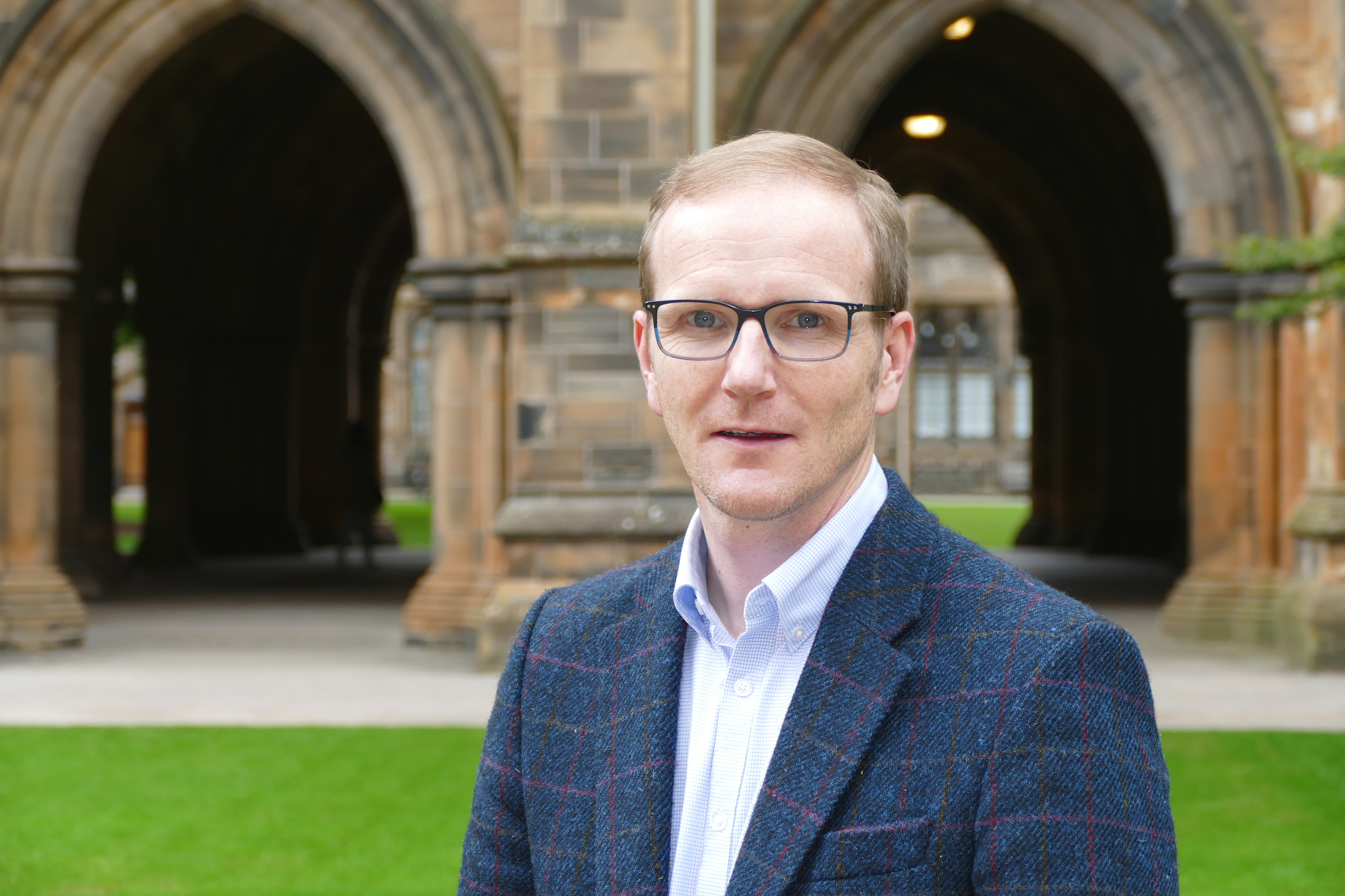 Professor Graeme Roy standing at the cloisters