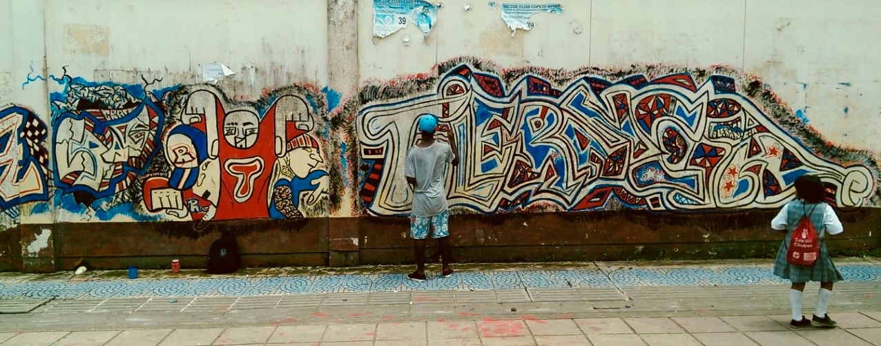 Child painting graffiti on street