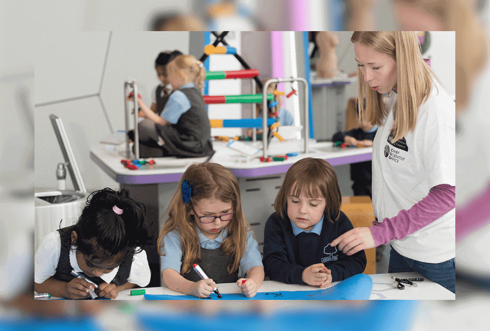 Three children and a researcher engaged in activity and discussion in the Science Centre