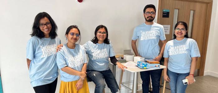 picture of researchers at the Byres Community Hub community day in June 2023 standing next to a stall