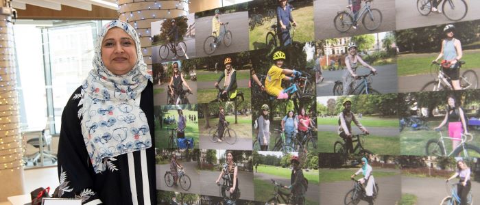 Photo of a person standing next to a board of photographs