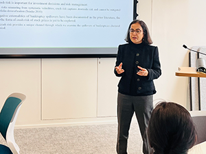 Academic presenting standing in front of a PowerPoint slide screen