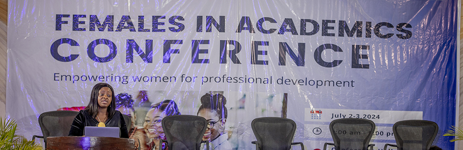 Dr Josephine Adekola presenting in front of a females in academics conference banner