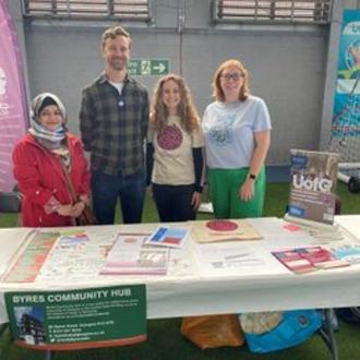 Four University of Glasgow staff members standing behind a table