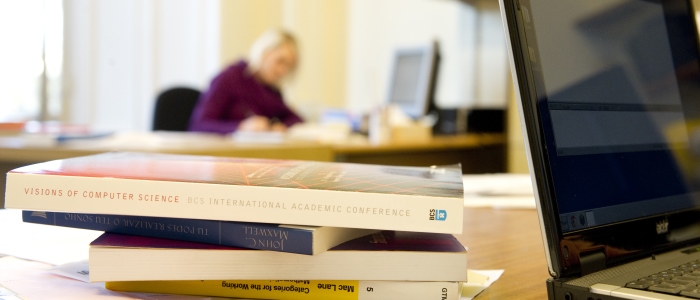 Laptop on desk with books