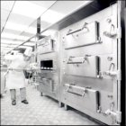 A chef using the bread oven in the Galley.