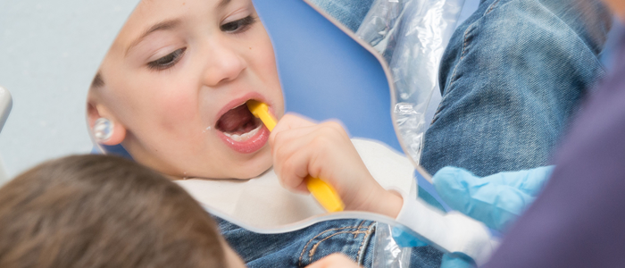 A child brushes teeth in a mirror