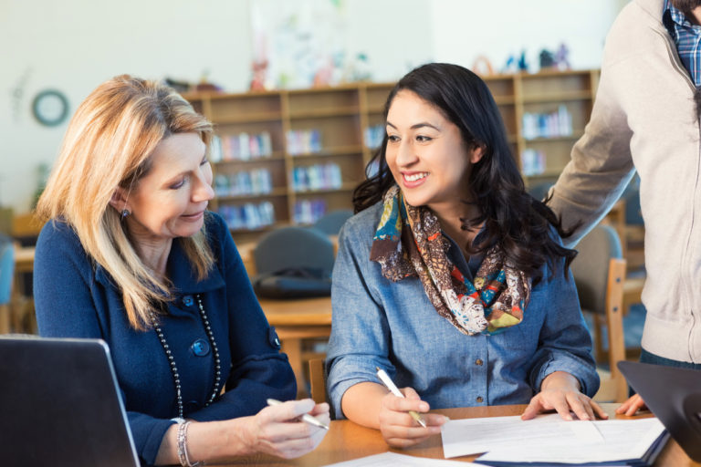 Older female talking to a younger female in a library style setting ,768x512px