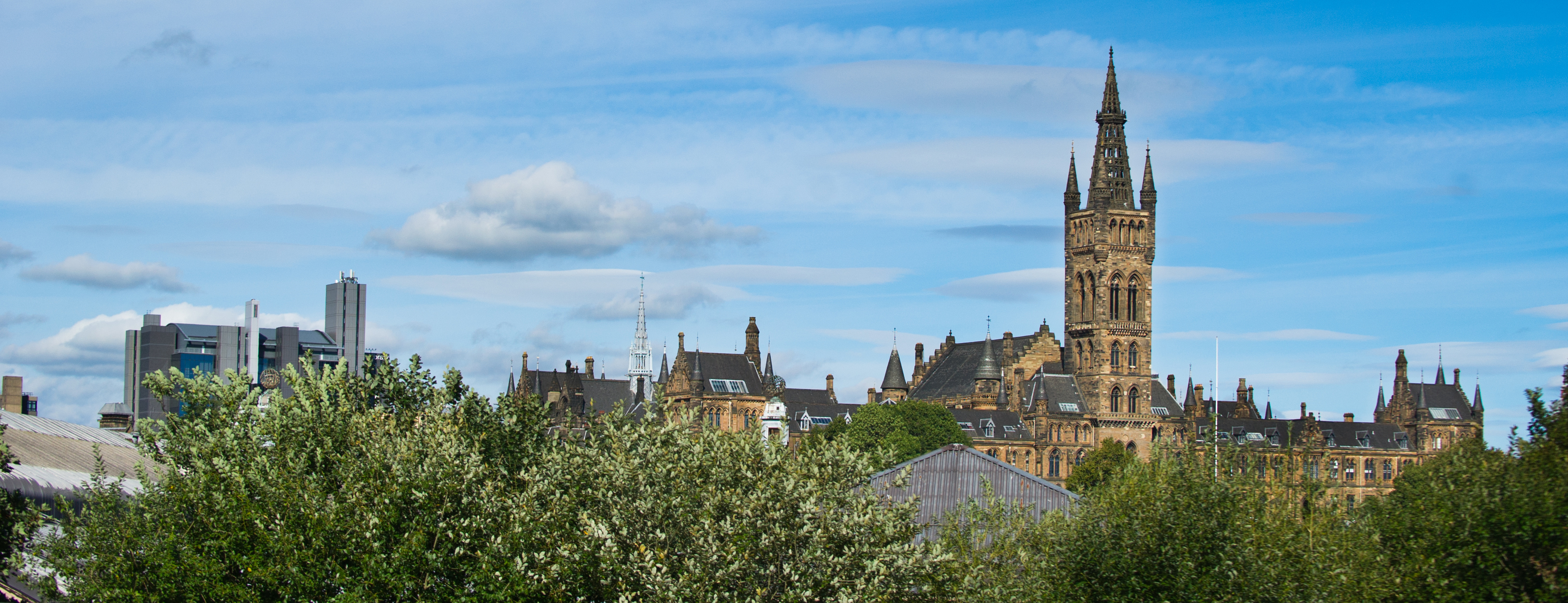 Glasgow University tower peeking out of some foliage 