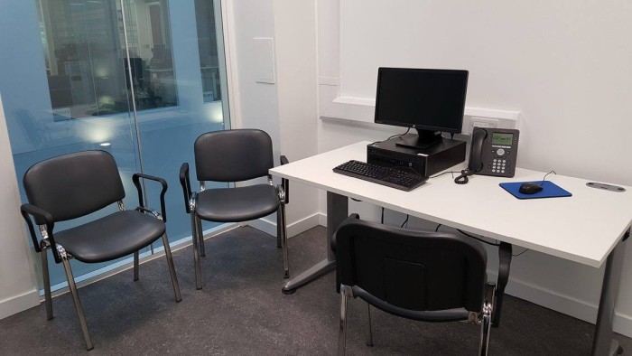 Flat floored interview room with chairs and desk with PC and telephone