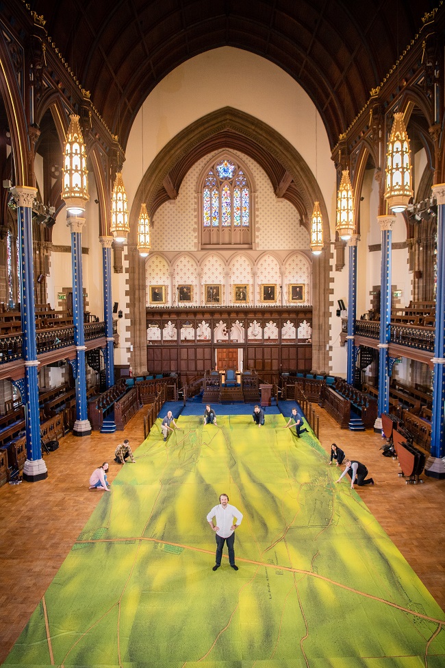 A group photo of Waterloo Replayed: The Great Game staff and students and gigantic map