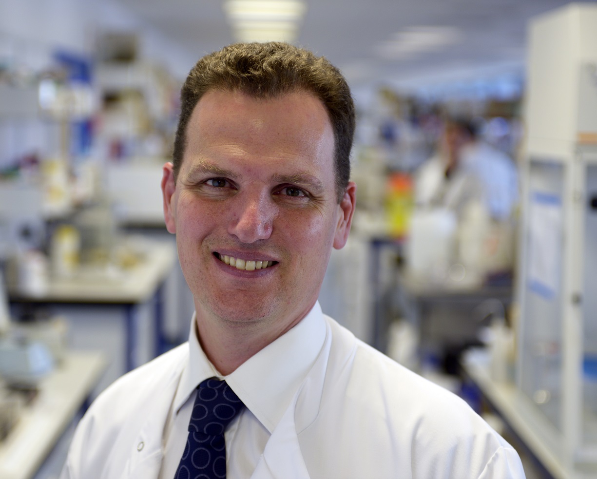 Prof Iain McInnes in lab coat in lab