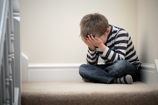 Upset child sitting on the stairs