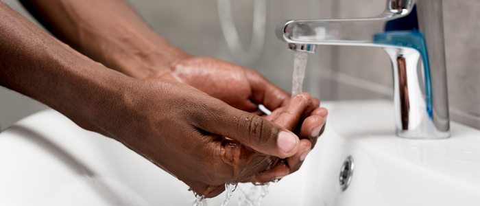 Person washing hands at sink