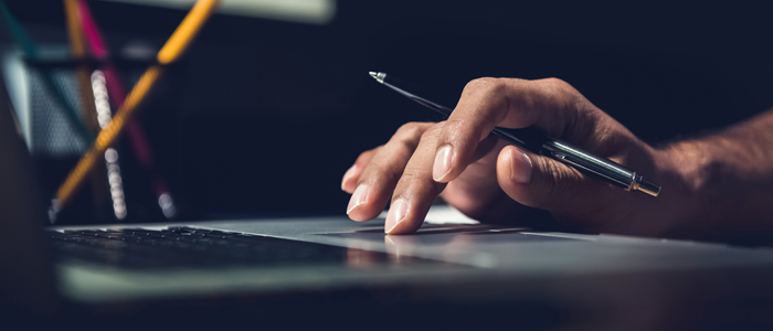 Photo of person's hands working at laptop