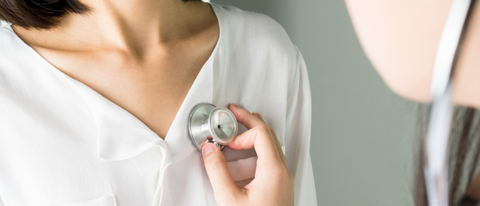 Photo of doctor listening to woman's heartbeat with stethoscope