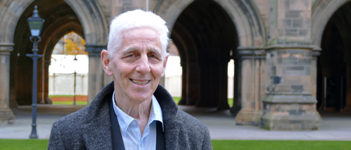 Professor David Nicol standing in front of the cloisters