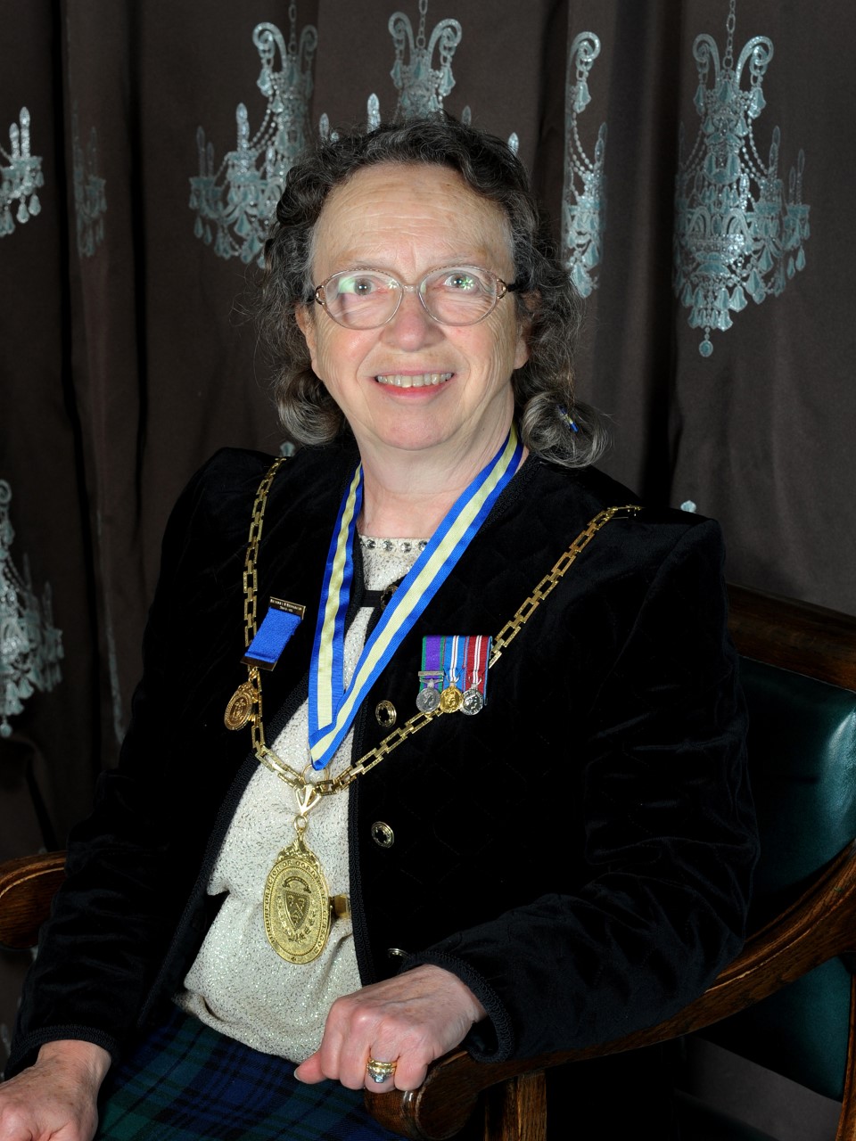 Dr Beverly Bergman sitting in a chair, smiling facing the camera