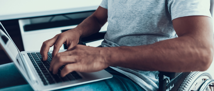 Photo of man in wheelchair using laptoop