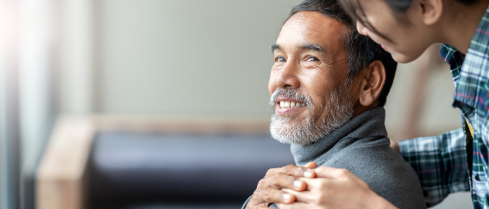 Man smiling with hand on shoulder