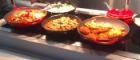 Prepared food on display sitting under heat plates 