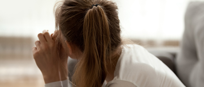 Photo of back view of young woman sitting in sofa