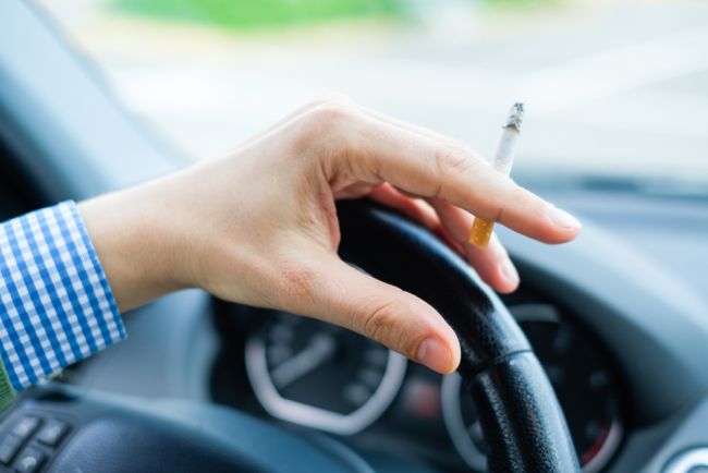 Person holding a cigarette while in a vehicle