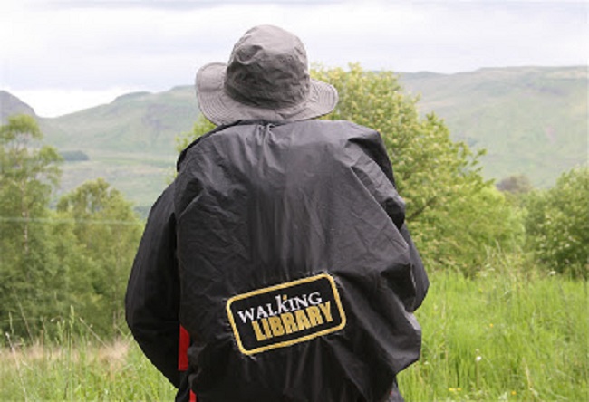 An image of Professor Deirdre Heddon wearing a backpack with Walking Library written on it.