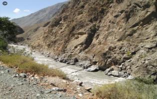 Swiftly flowing mountain stream with narrow footbridge, Chitral.  HWFP, Pakistan.  The footbridges are often the only way of moving between the very isolated villages in these regions.  They need regular repair because of damage by flash floods