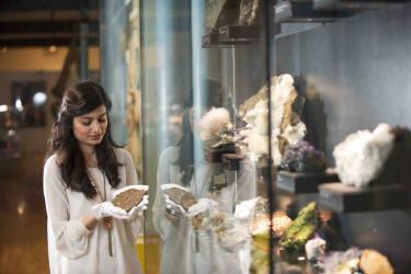 A woman holding a rock from the Hunterian