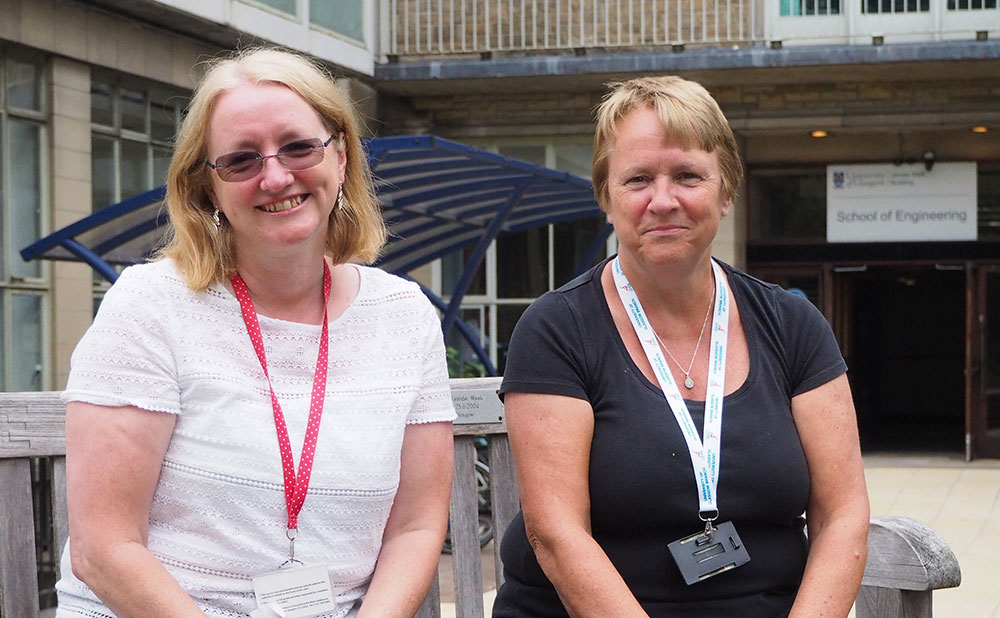 Photo of Helen McLellan and Susan Ferguson sitting outside James Watt South building.