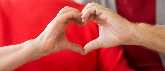 Photo of 2 people making heart shape with hands