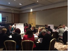 delegates attending a conference venue, gathered around circular tables