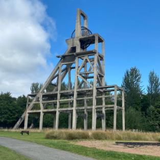 A large metal structure outside with struts creating the shape of an A. It held the winding gear at the head of coalmining pit. Source: Ewan Gibbs, 2021