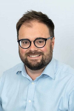 Head and shoulders image of a male wearing glasses 