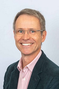 Male facing the camera wearing shirt and blazer 