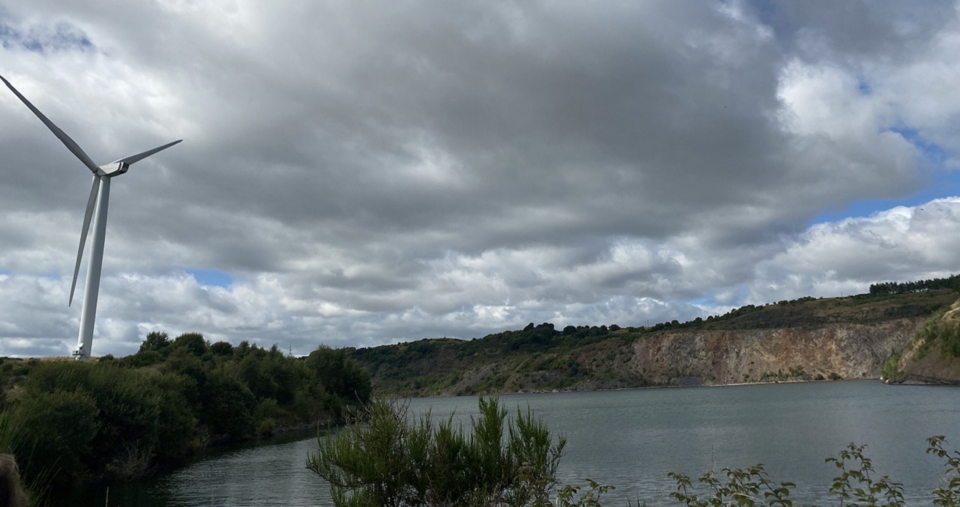 Wind turbine on a hill next to a lake (loch) with steep sides. Source: Ewan Gibbs, 2021