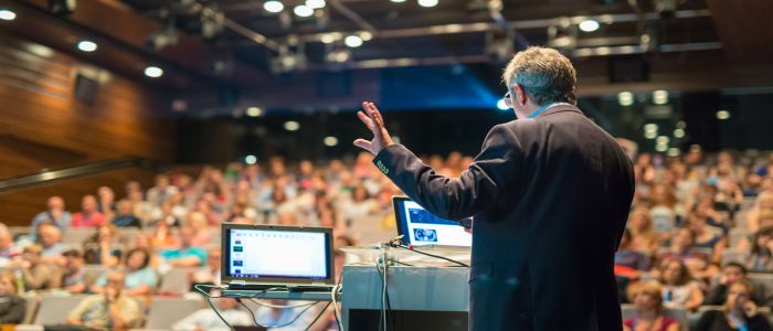 A speaker presenting in front of an audience