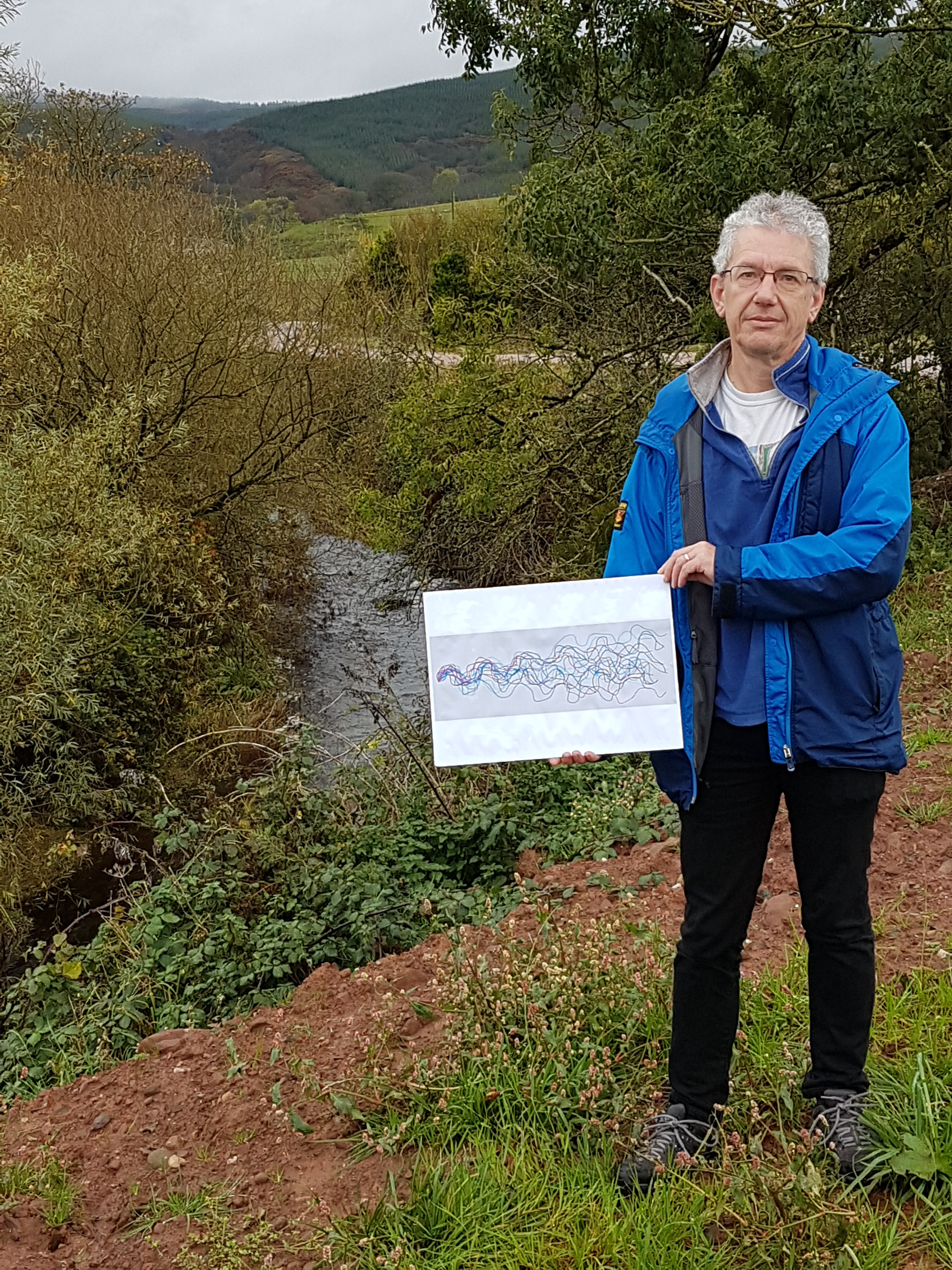 Man holding artwork by river