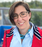 A head and shoulders shot of Dr Carmen Huesa outdoors and wearing a red coat