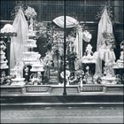 Photograph of a window display of wedding cakes and bridal bouquets. The price of wedding cakes then was 2/6d per lb, May 1929.  (GUAS Ref: HF 51/8/1/1/3 photo 15. Copyright reserved.)