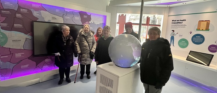 Photo of a community group standing next to an exhibit in the Clarice Pears building