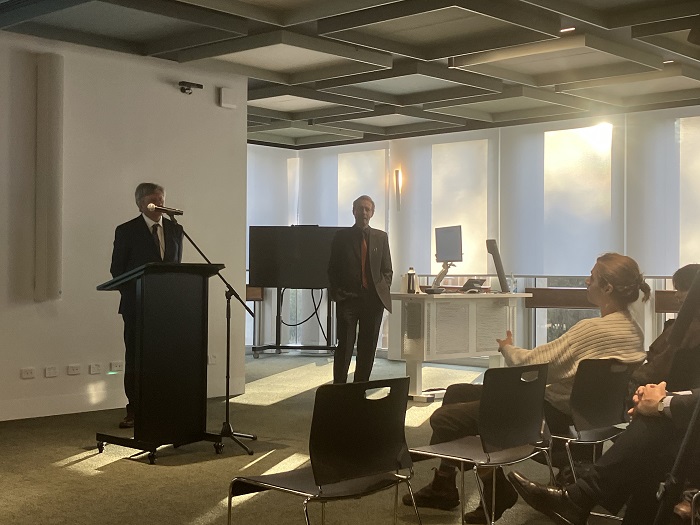 Speaker at a podium with people in the audience. Source: Australian National University