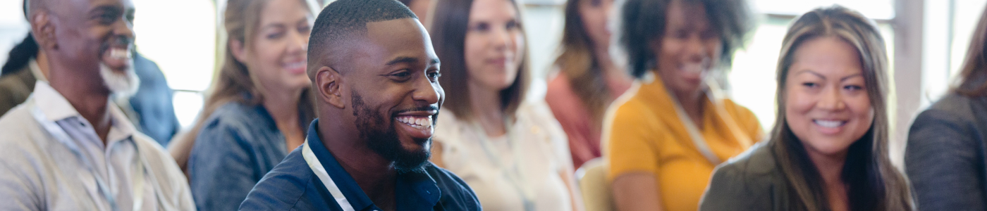 Students sitting in a conference smiling