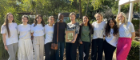 A group of students from UofG FemEng smiling in a line. In the centre are Eunice Ntobedzi Hannah and High Commissioner Sian Price. Sian Price holds a frame in which sits a portrait of Eleanor Emery. 